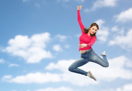 smiling young woman jumping in airの写真素材