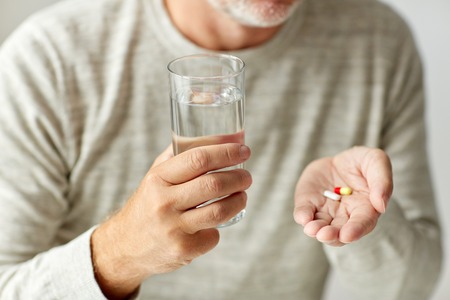 close up of hands with medicine pills and waterの写真素材