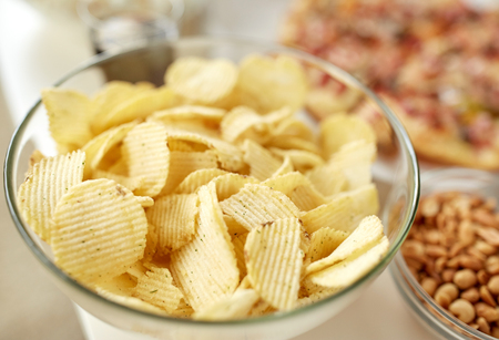 close up of crunchy potato crisps in glass bowlの写真素材