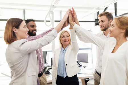 happy business team making high five at officeの写真素材
