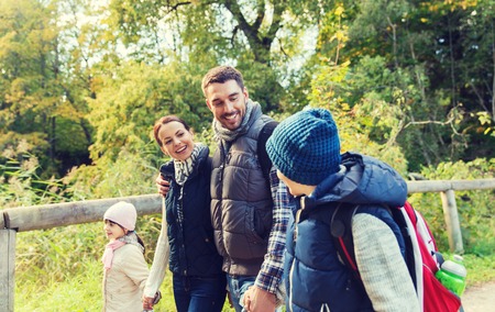 happy family with backpacks hiking in woodsの写真素材