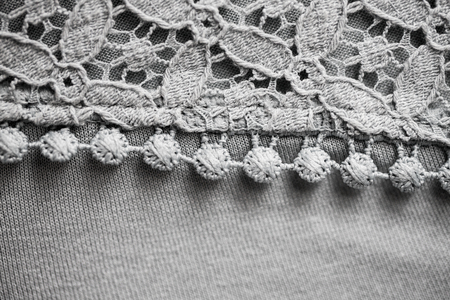 textile and clothes concept - close up of lace fabric or clothing item