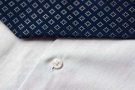 clothing, formal wear, fashion and objects concept - close up of shirt and patterned tie