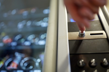 hand pushing button on vending machine