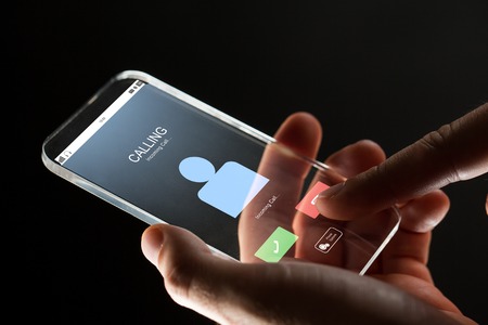 close up of hand with incoming call on smartphone