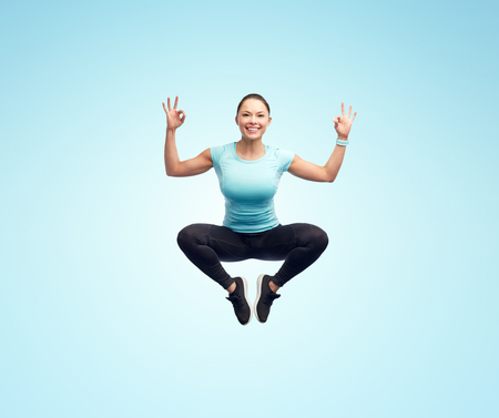 happy smiling sporty young woman jumping in air