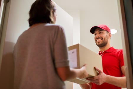 happy delivery man giving parcel box to customerの写真素材