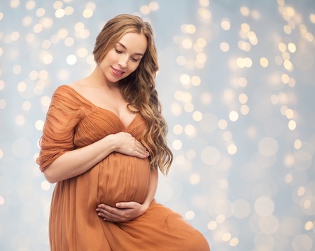 happy pregnant woman touching her big bellyの写真素材