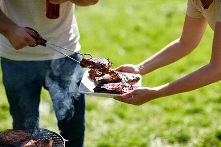 man cooking meat at summer party barbecueの写真素材