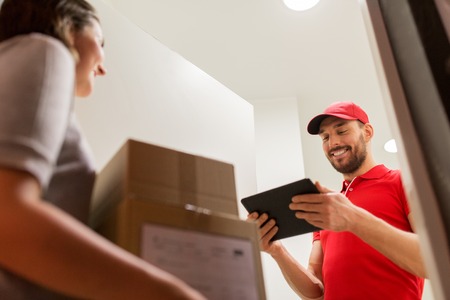 deliveryman with tablet pc and customer with boxesの写真素材