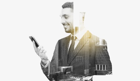 business, technology and people concept - smiling businessman texting on smartphone over city buildings and double exposure effectの写真素材