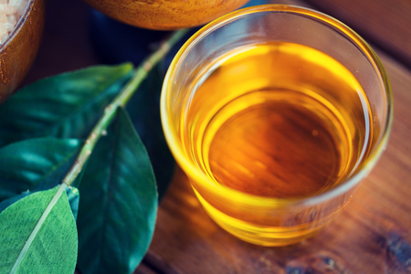 close up of honey in glass with leaves on woodの写真素材