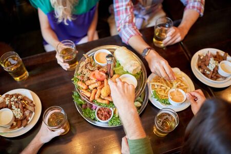 friends eating and drinking at bar or pub