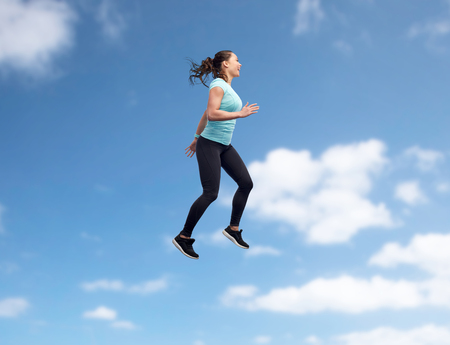 happy smiling sporty young woman jumping in air