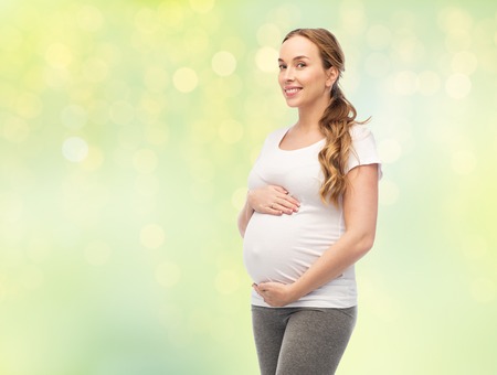 happy pregnant woman touching her big belly