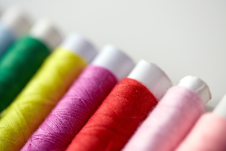 row of colorful thread spools on table