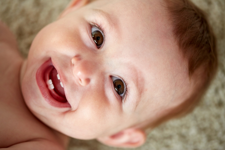 childhood, babyhood, emotions and people concept - close up of happy little baby boy or girl faceの写真素材