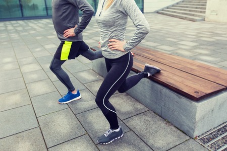 fitness, sport, people, exercising and lifestyle concept - close up of couple couple doing lunge...