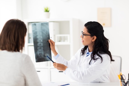doctor and patient with spine x-ray at hospital