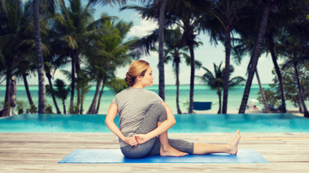 woman making yoga in twist pose on matの写真素材