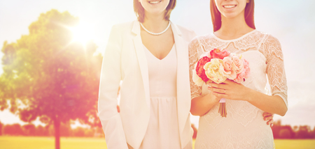 close up of happy lesbian couple with flowersの写真素材