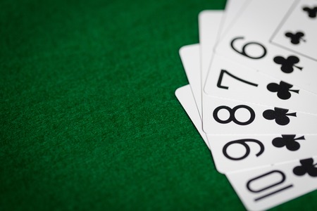 poker hand of playing cards on green casino cloth