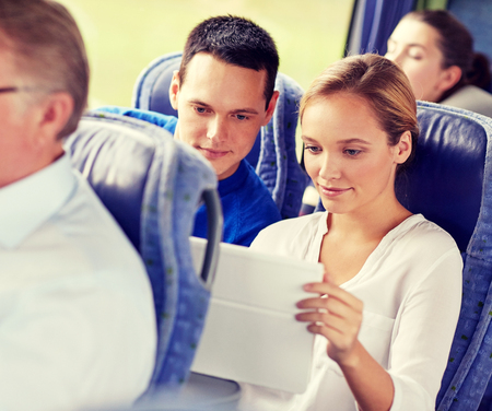 happy couple with tablet pc in travel busの写真素材