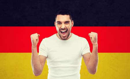 angry man showing fists over german flagの写真素材