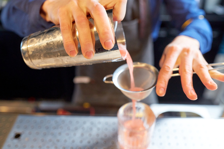 barman with shaker preparing cocktail at barの写真素材