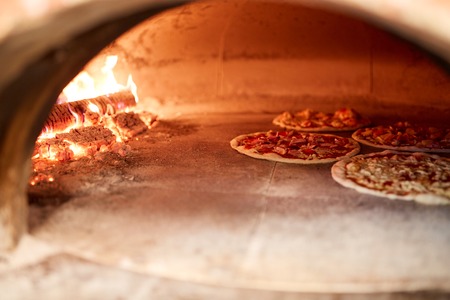 pizza baking in oven at pizzeriaの写真素材