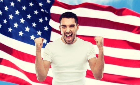 angry man showing fists over american flagの写真素材