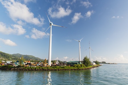 renewable energy, technology and power concept - turbines at wind farm on sea shoreの写真素材