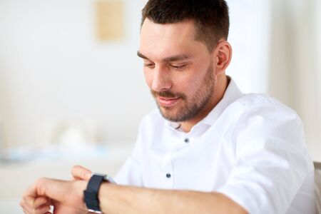 close up of businessman with smartwatch at officeの写真素材