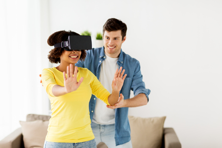 happy couple with virtual reality headset at homeの写真素材