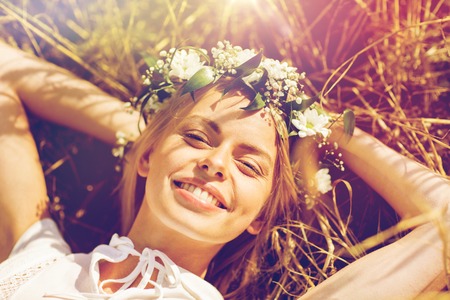 happy woman in wreath of flowers lying on strawの写真素材