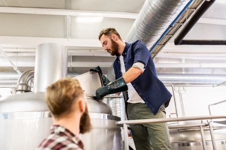 manufacture, business and people concept - men working at craft brewery or beer plantの写真素材