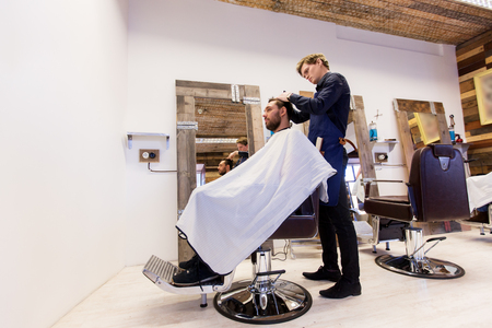 man and barber cutting hair at barbershopの写真素材