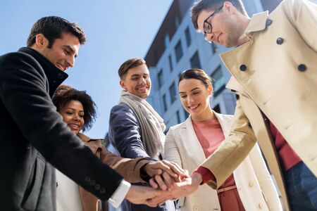group of happy people holding hands in cityの写真素材
