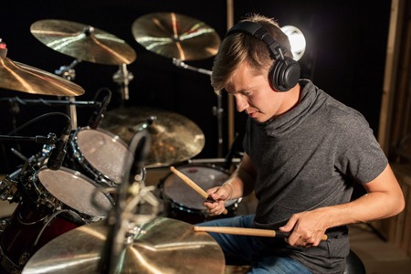 male musician playing drums and cymbals at concert