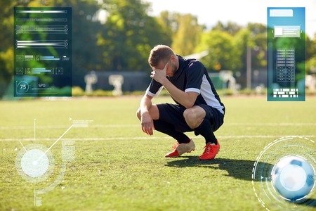 sad soccer player with ball on football fieldの写真素材