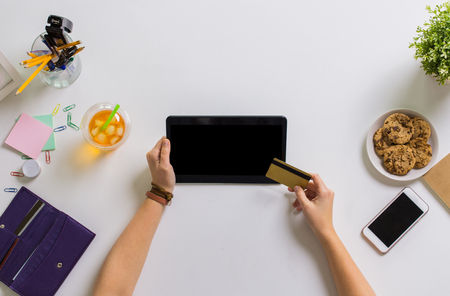 hands with tablet pc and credit card at tableの写真素材