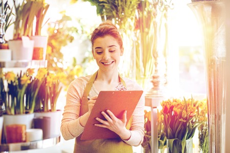 florist woman with clipboard at flower shopの写真素材
