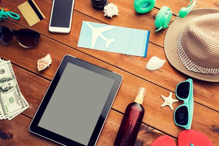 vacation, travel, tourism, technology and objects concept - close up of tablet pc computer and travel stuffの写真素材