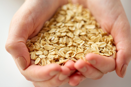 close up of hands holding oat flakesの写真素材