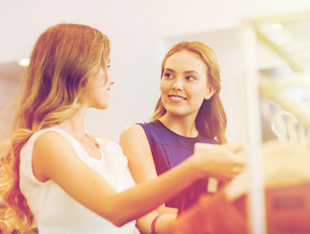 happy women with shopping bags at clothing shopの写真素材