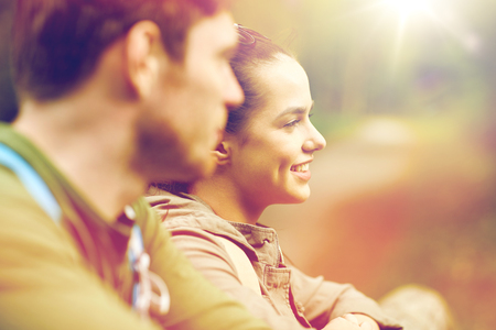 smiling couple with backpacks in natureの写真素材