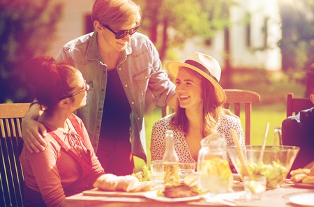 happy friends having dinner at summer garden partyの写真素材