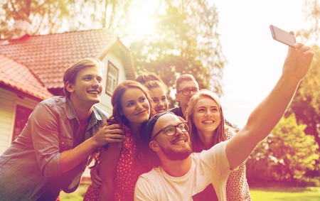 friends taking selfie at party in summer garden