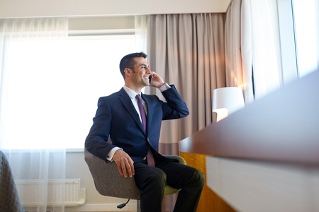 businessman calling on smartphone at hotel roomの写真素材