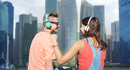 teenage couple with headphones on river berthの写真素材
